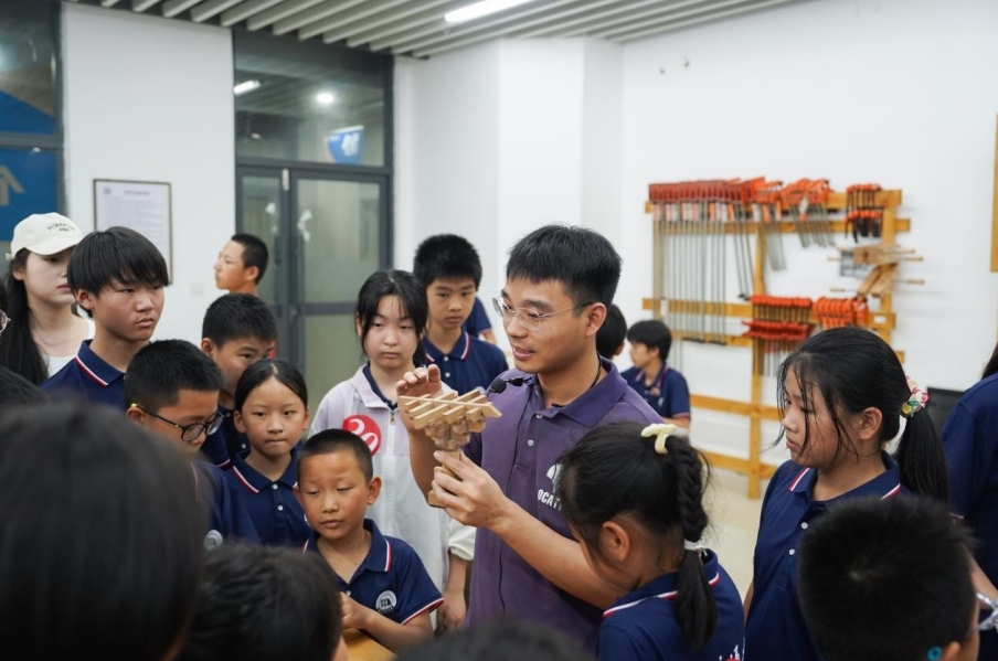 2026世界杯官网基础实验与工程实践中心老师正在给研学团成员讲解榫卯工艺。